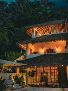 een gebouw met een rieten dak 's nachts bij Vayu Retreat Villas in Coronado