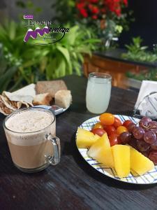 a table with plates of fruit and a cup of coffee at Hostel Estacion Mendoza in Mendoza