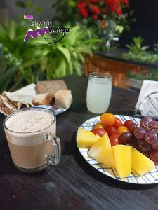 una mesa con platos de fruta y una taza de café en Hostel Estacion Mendoza en Mendoza