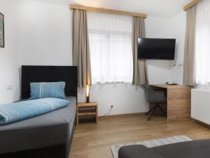 a bedroom with a bed and a flat screen tv at Schönauer Top 1 in Mariastein