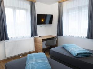 a bedroom with a bed and a desk with a television at Schönauer Top 1 in Mariastein