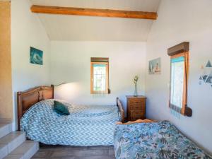 1 dormitorio con 1 cama, vestidor y 2 ventanas en Le Tourel, en Saint-Cernin-de-lʼHerm