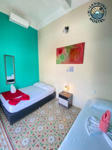 een kamer met 2 bedden en een spiegel bij La Viduka Hostel in Cartagena