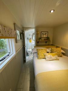 1 Schlafzimmer mit 2 Betten mit gelben und weißen Kissen in der Unterkunft Woodmans Huts in Haverthwaite