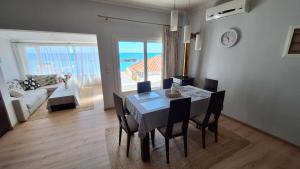 a dining room with a table and chairs with a view of the ocean at Endless Blue in Pythagoreio