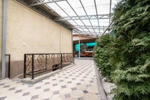 a walkway in a building with a fence and plants at Half,Гостевой дом in Karakol