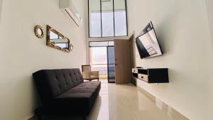 a living room with a couch and a flat screen tv at Vista Hills Loft & Jacuzzi in Guayaquil