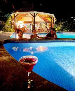 eine Gruppe von Personen in einem Pool mit einem Drink in der Unterkunft MisMiriam in Tortuguero