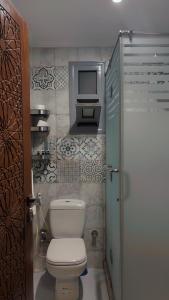 a bathroom with a toilet and a tv on the wall at Queen cleopatra sphinx view in Cairo