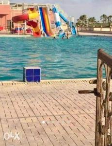 a bench next to a water park with a water slide at الساحل الشمالي in Dawwār Şaqr