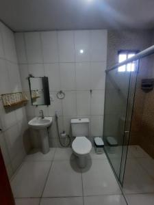 a small bathroom with a toilet and a shower at Casa Buzios do Francês in Marechal Deodoro