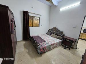 um quarto com uma cama e uma janela em SYED Rest House em Karachi