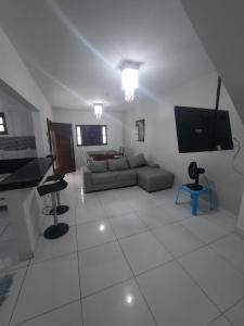 sala de estar con sofá y TV en Casa Buzios do Francês, en Marechal Deodoro