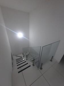 um quarto branco com um banco e uma luz em Casa Buzios do Francês em Marechal Deodoro