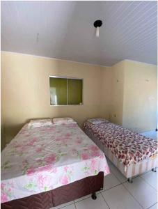 1 dormitorio con 2 camas y TV en la pared en Pousada Valente en Barreirinhas