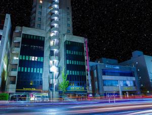 - un bâtiment de nuit avec une rue en face dans l'établissement Hotel Alpha Inn Akita, à Akita