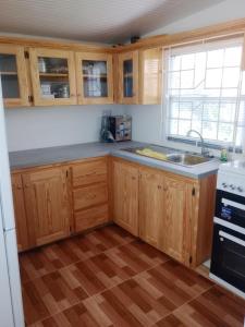 a kitchen with wooden cabinets and a sink at Impeccable 2-Bed House in St Patrick's in Celeste