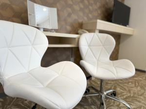 two white chairs and a desk in a room at Hotel Alpha Inn Akita in Akita