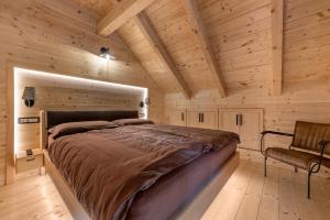 a bedroom with a large bed in a wooden cabin at Holiday house with a swimming pool Brod na Kupi, Gorski kotar - 23012 in Brod na Kupi