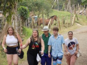 a group of people walking down a dirt road at OLIVA´S HOUSE in Jardin