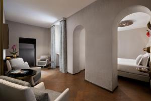 um quarto de hotel com uma cama e uma sala de estar em The Pantheon Iconic Rome Hotel, Autograph Collection em Roma