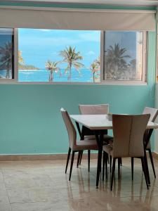 a dining room with a table and chairs and a view of the ocean at Alojamientos Laila Sai y Zaida in San Andrés