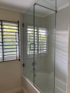 La salle de bains est pourvue d'une douche avec une porte en verre. dans l'établissement SEA VIEW - Sunset Villa Family home in Richmond, à Richmond
