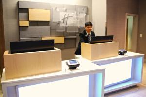 a man standing in front of a desk with a laptop at Holiday Inn Express Vancouver Airport-Richmond, an IHG Hotel in Richmond