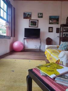 uma sala de estar com um sofá e uma mesa em Casa Centenária localizada no calçadão de SLP em São Luiz do Paraitinga
