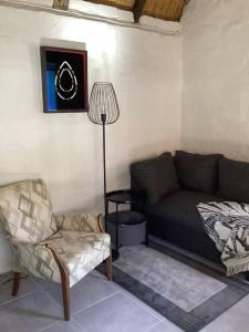 a living room with a couch and a lamp at Rosewood Cottage Apartment in Himeville