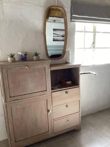 a wooden dresser with a mirror on top of it at Rosewood Cottage Apartment in Himeville