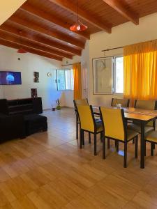 ein Wohnzimmer mit einem Tisch und gelben Stühlen in der Unterkunft ALQUILER X DIA Merlina in Catriel