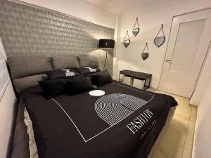um quarto com uma cama com um edredão preto em שבטי ישראל - דירת בוטיק em Haifa