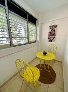 uma mesa amarela e duas cadeiras num quarto em שבטי ישראל - דירת בוטיק em Haifa