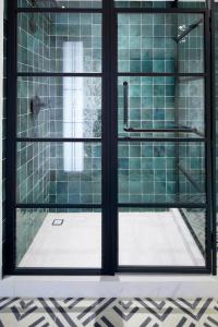 a bathroom with a shower with green tiles at Kimpton Virgilio in Mexico City