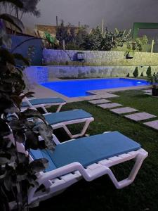 een groep ligstoelen naast een zwembad bij Villa Elizabeth - Tú Hermosa Casa de Campo in Lima