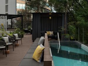 eine Terrasse mit Swimmingpool neben einem Gebäude in der Unterkunft Kimpton Virgilio Polanco by IHG in Mexiko-Stadt