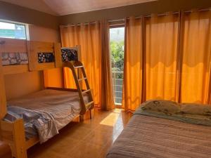 a bedroom with two bunk beds and a window at Villa Elizabeth - Tú Hermosa Casa de Campo in Lima