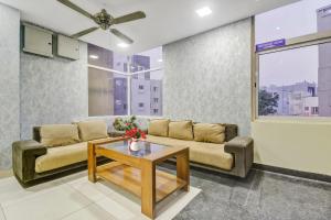- un salon avec un canapé et une table basse dans l'établissement Collection O 1019 Galaxy Suites, à Hyderabad
