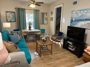 uma sala de estar com um sofá e uma televisão em Palm Beach Mermaid em West Palm Beach
