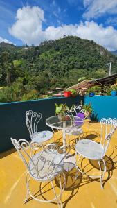 una mesa y sillas en un balcón con vistas en Entre Cantos - Hospedaje Rural en Ibagué
