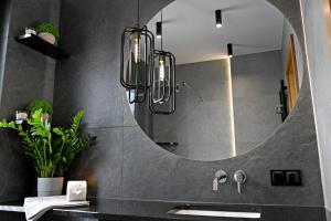 La salle de bains est pourvue d'un grand miroir et d'un lavabo. dans l'établissement APARTAMENT JANETTA domek nad jeziorem, à Stężyca 77 autres photos
