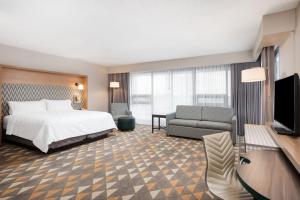 um quarto de hotel com uma cama e um sofá em Holiday Inn Toronto Airport East, an IHG Hotel em Toronto