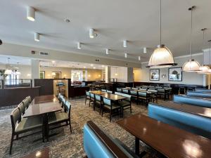 uma sala de jantar com mesas e cadeiras e mesa de cabeceira em Holiday Inn Toronto Airport East, an IHG Hotel em Toronto