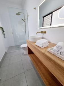 a bathroom with a sink and a toilet and a mirror at Holiday on Hibiscus in Urangan +7 photos
