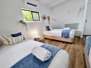 a bedroom with two beds and a window at Holiday on Hibiscus in Urangan