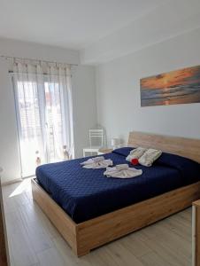 Un dormitorio con una cama azul con toallas. en Appartamento Moderno in Centro città en SantʼAgata di Militello