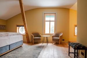 a bedroom with a bed and two chairs and a table at Villa Klainguti in Pontresina