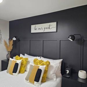 a bed with a black headboard with a sign on it at Atlantic City Bungalow Retreat in Atlantic City