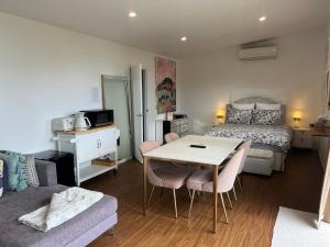 1 dormitorio con 1 cama, mesa y sillas en Gold Coast Retreat, en Ormeau